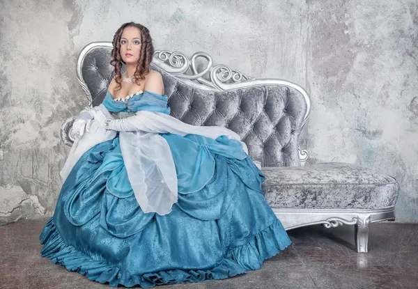 Hermosa mujer en vestido medieval en el sofá — Foto de Stock