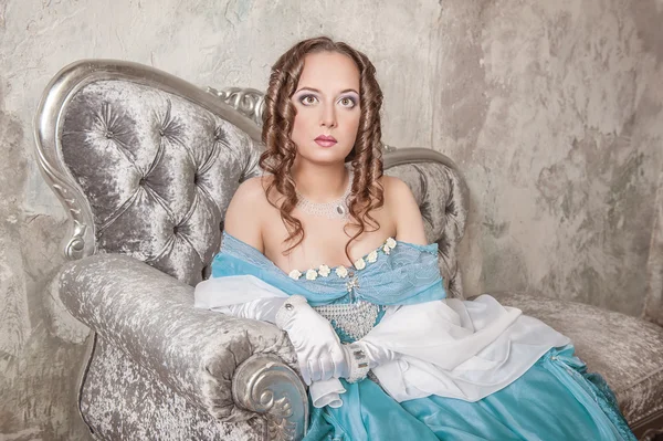 Beautiful woman in medieval dress on the sofa — Stock Photo, Image