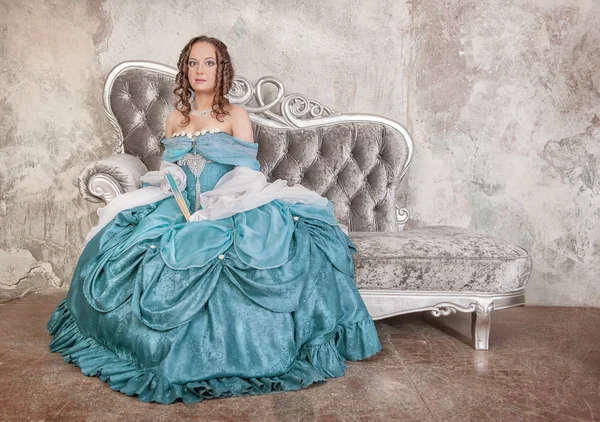 Schöne Frau im mittelalterlichen Kleid auf dem Sofa — Stockfoto