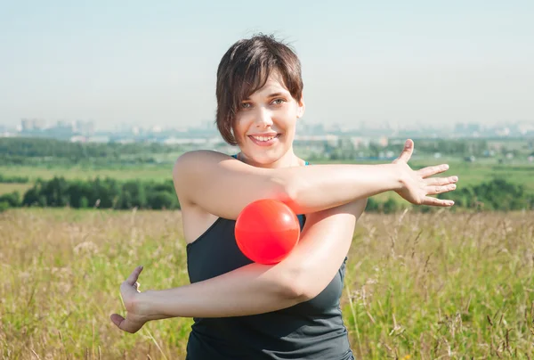 Beautiful woman exercising with ball — ストック写真