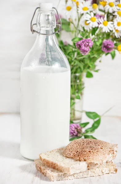 Leche fresca en botella pasada de moda y pan casero —  Fotos de Stock