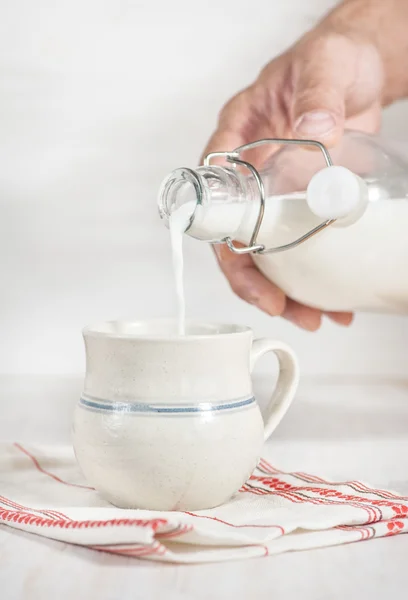 Hombre mano verter la leche de botella —  Fotos de Stock