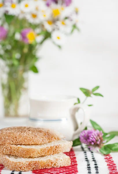 Hausgemachtes Brot und Milch im Keramikbecher — Stockfoto