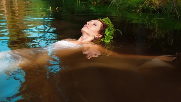 Junge schöne ertrunkene Frau liegt im Wasser — Stockfoto