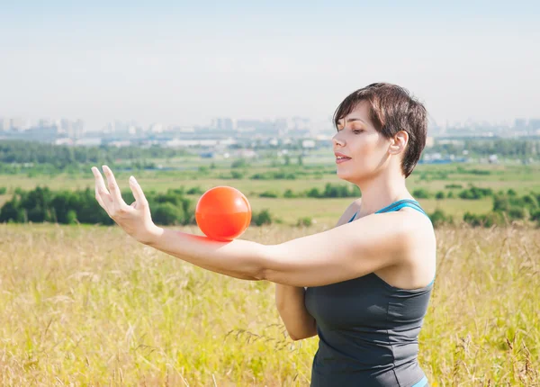 Beautiful plus size woman exercising with ball — Stock Photo, Image