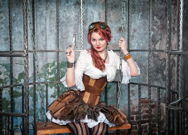 Schöne Steampunk-Frau im Käfig mit Waffe — Stockfoto