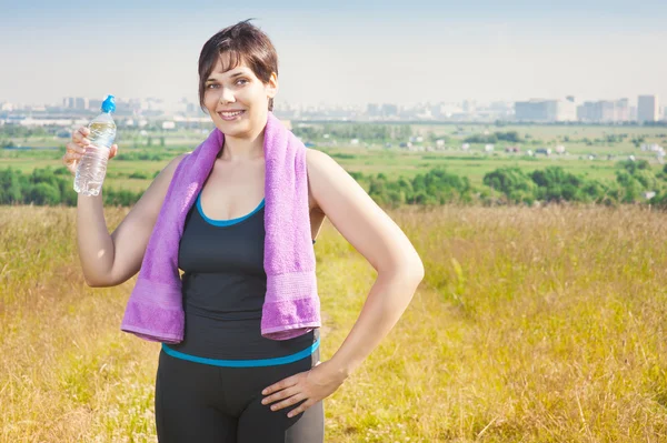Fitness plus Size Frau mit Handtuch und Wasserflasche — Stockfoto