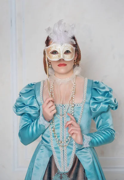 美しいです若いです女性で中世のスタイルのドレスとともにマスクで部屋 — ストック写真