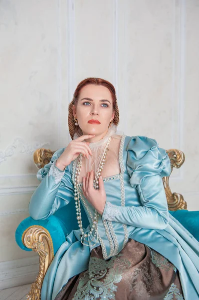 美しいです若いです女性で中世のスタイルブルードレス座っていますザArmchai — ストック写真