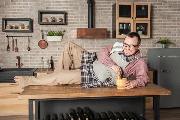 Divertido Joven Guapo Sonriente Vistiendo Pinafore Con Toalla Acostado Mesa — Foto de Stock