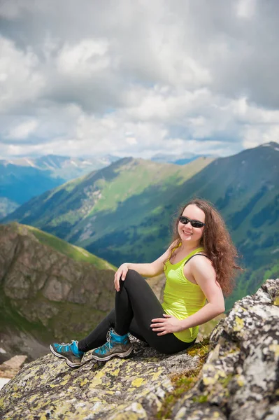 美丽的女徒步旅行者坐在山顶上 — 图库照片