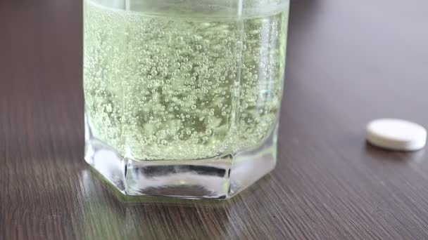 Аспирин или шипучая таблетка, сверкающие пузырьки в стакане воды — стоковое видео