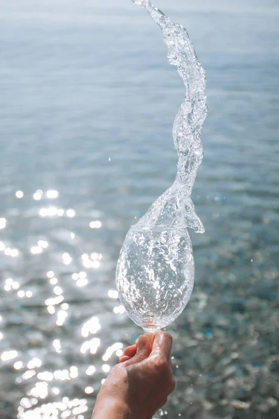 Spraya Vatten Droppar Från Vinglas Mot Bakgrund Havet — Stockfoto