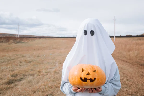 Dziecko Halloween Duch Kostium Gospodarstwa Rzeźbione Dyni Halloween — Zdjęcie stockowe