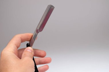 Beyaz bir arka planda düz bir jilet tutarken.