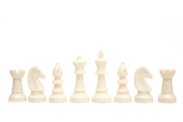 一套白色国际象棋棋子在白色的背景上排成单行 — 图库照片
