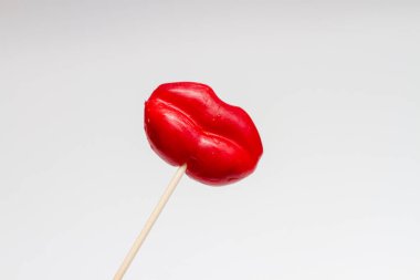 Red Lips Lollipop. Lollipop candy in the shape of red lips on white background. Valentine concept.