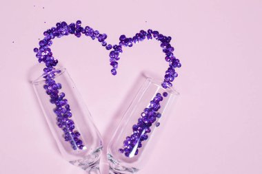 Kalp şeklinde dağılmış mor pullu şampanya kadehi. Sevgililer Günü tasarımı ve boş alan
