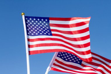 American Flag against the blue sky. Celebrating Independence Day of America. USA flag waving in blue sky.