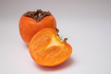 Taze hurma ve hurmaların yarısı beyaz arka planda izole edilmiş..