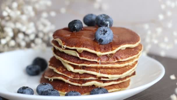 Madu menetes di tumpukan pancake dengan blueberry — Stok Video