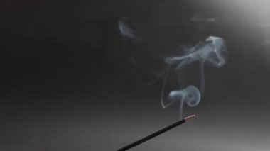 Kokulu tütsüden çıkan duman siyah arka plana yapışır.