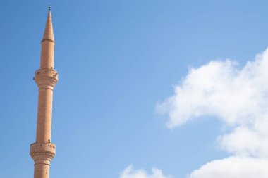 Mavi gökyüzüne karşı caminin minaresi.