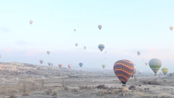 Balões de ar quente voando em terra da Capadócia, Turquia — Vídeo de Stock