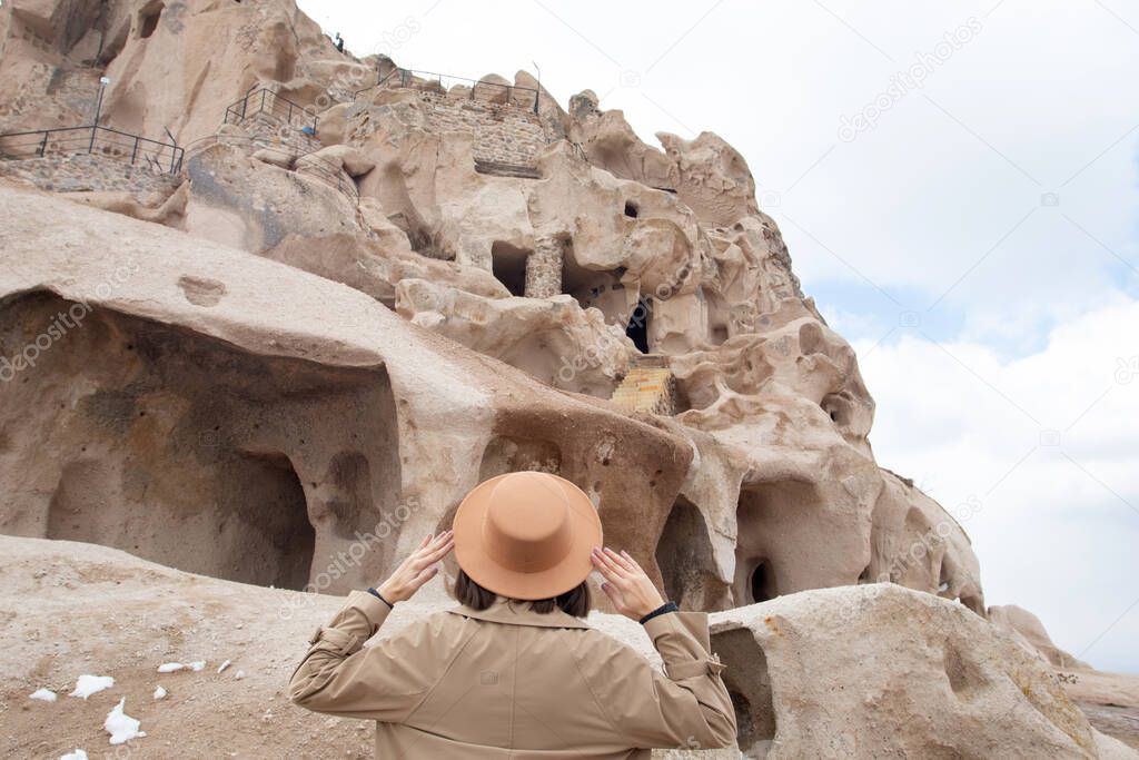 Woman in hat looking at Cappadocia landscape and Castle