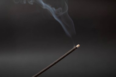 Siyah arka planda tütsü tüttürme çubuğu.