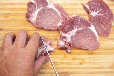 Mans mutfakta çiğ et kesiyor..