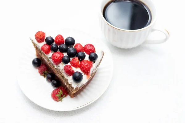 Kuchen Mit Beeren Auf Weißem Teller Und Schwarzer Tasse Kaffee — Stockfoto