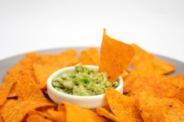 Guacamole sosu ve cipsler tabakta..