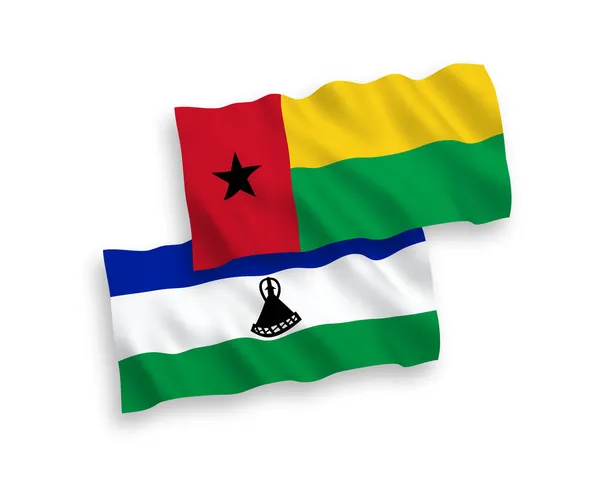 几内亚比绍共和国和莱索托在白色背景下隔离的国家病媒织物波浪旗 1比2的比例 — 图库矢量图片