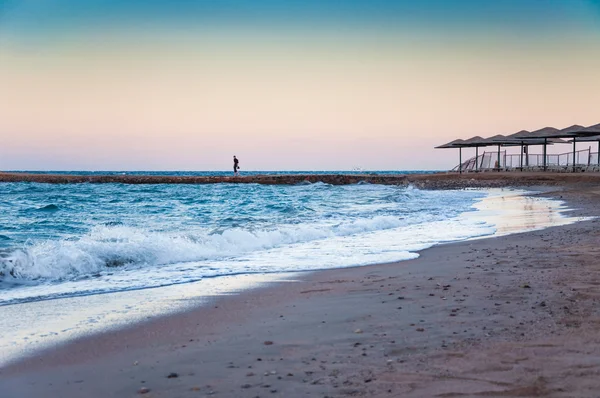 Schöne Meeresküste am Abend und einsame Gestalt eines Mannes in — Stockfoto