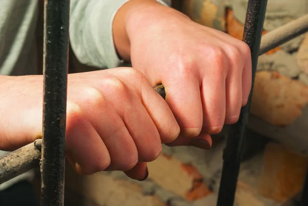 Hands behind the bars — Stock Photo, Image