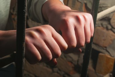 Ellerini parmaklıkların arkasında