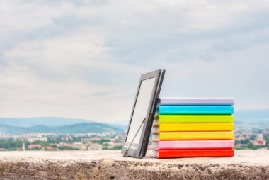 elektronik kitap okuyucu ile renkli kitap yığını