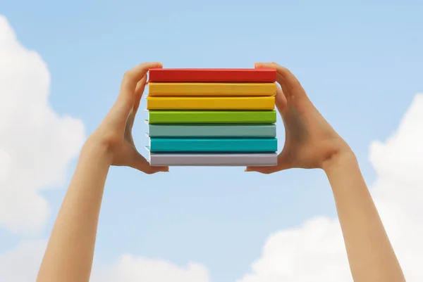 Manos sosteniendo coloridos libros de tapa dura —  Fotos de Stock