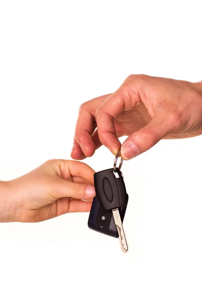 Mano masculina sosteniendo una llave del coche y entregándola a otra persona aislada —  Fotos de Stock