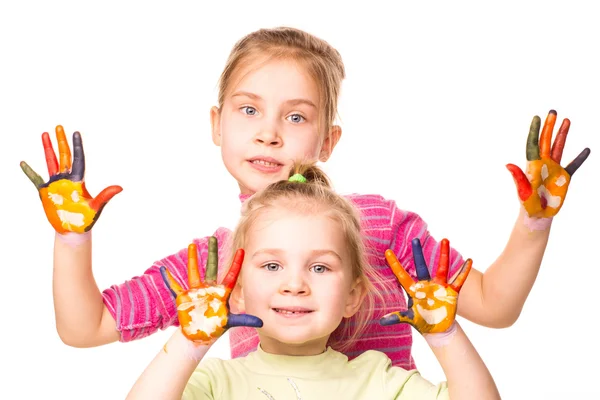 Two happy girls showing hands painted in bright colors — Stock Photo, Image