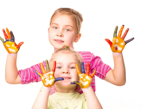 Two happy girls showing hands painted in bright colors — Stock Photo, Image