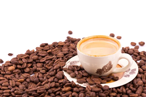 Kávová zrna a šálek kávy pozadí — Stock fotografie