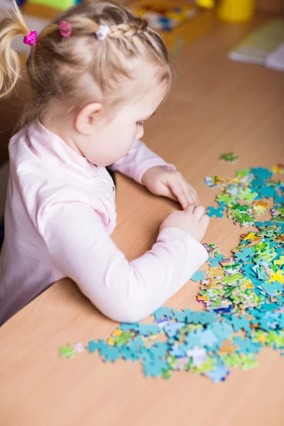 Linda niña resolviendo puzzles — Foto de Stock