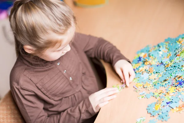 Linda niña resolviendo puzzles —  Fotos de Stock