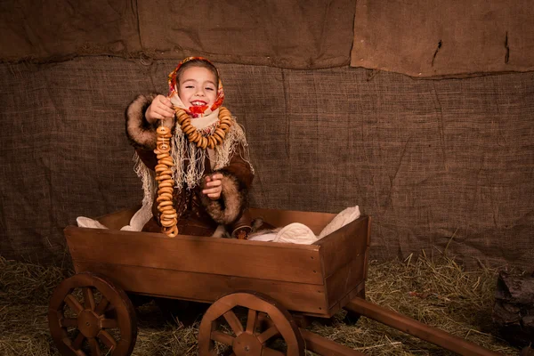 Belle fille russe dans un châle assis dans un chariot — Photo