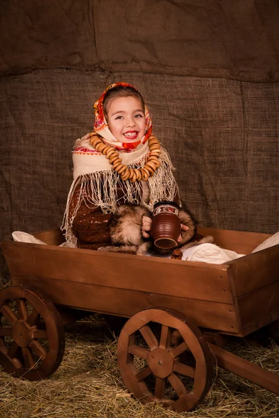 Belle fille russe dans un châle assis dans un chariot — Photo
