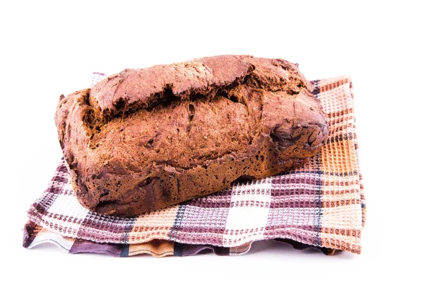 Pan marrón casero fresco con cereales en una toalla de cocina —  Fotos de Stock