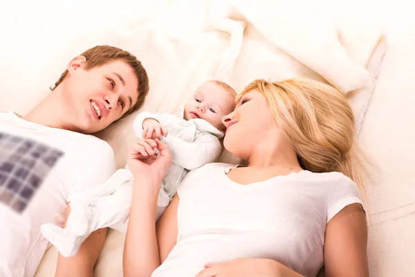 年轻幸福的家庭： 妈妈、 爸爸和宝宝躺在 — 图库照片