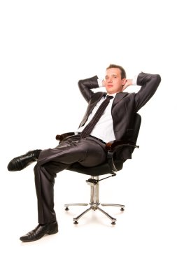 kendinden emin gülümseyen genç işadamı rahatlatıcı bir sandalyenin üstüne
